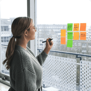 Chica apuntando en posits pegados en la ventana